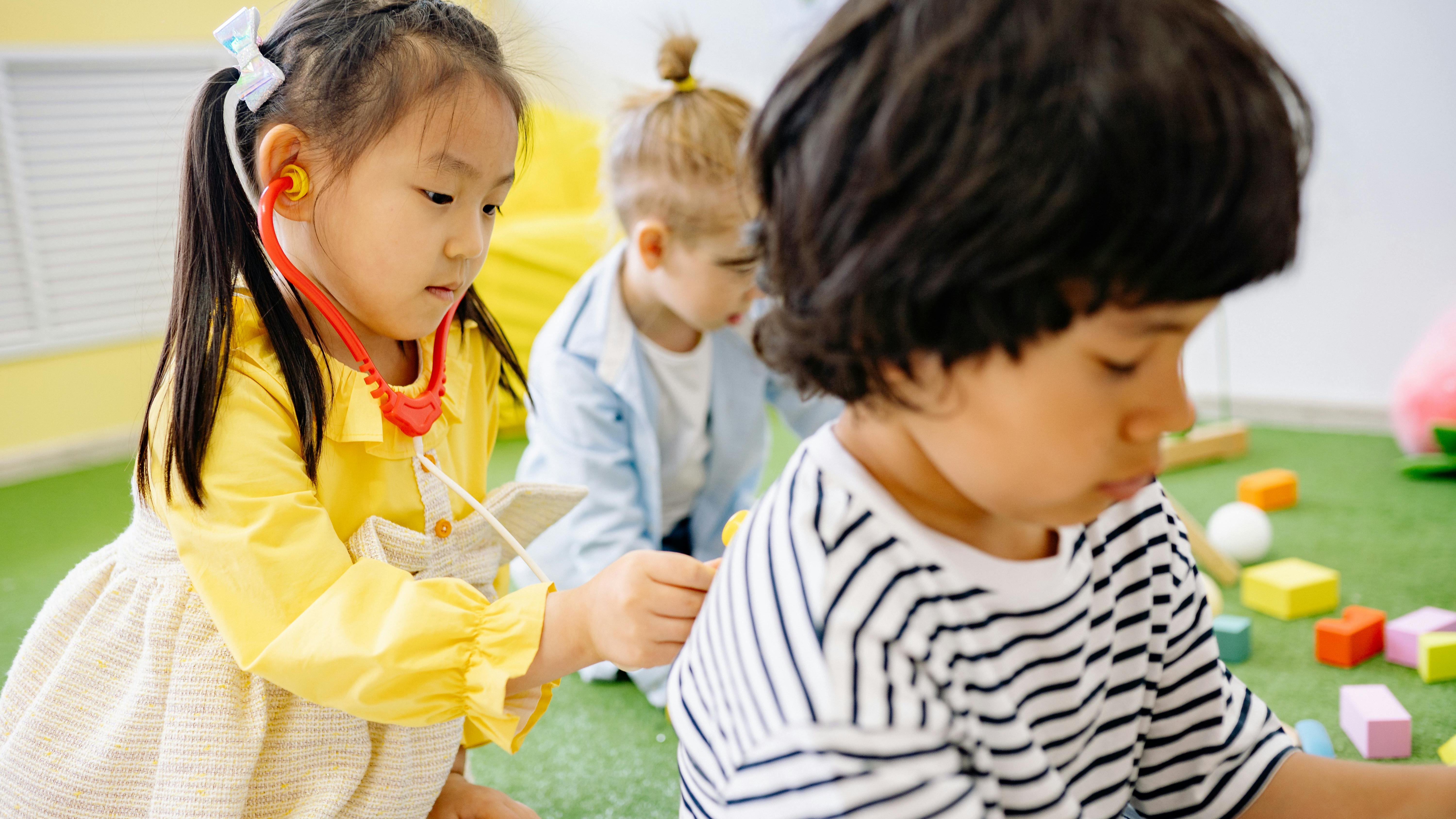 Preschoolers happily interacting outdoors, social conflict resolution.