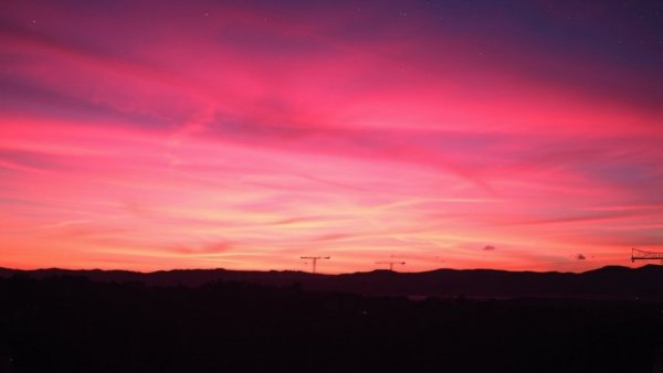 Colorful night sky over hills and rooftops, uplifting stories for entrepreneurs.