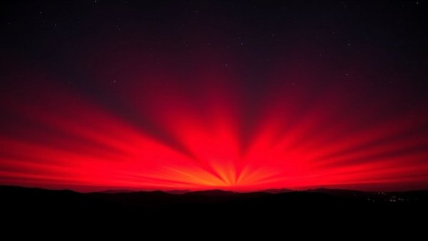Vivid red sky phenomenon over hills, Positive Business News image.