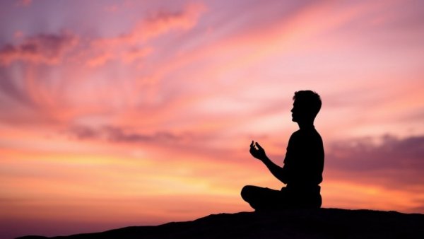 Serene person meditating with pastel sky background