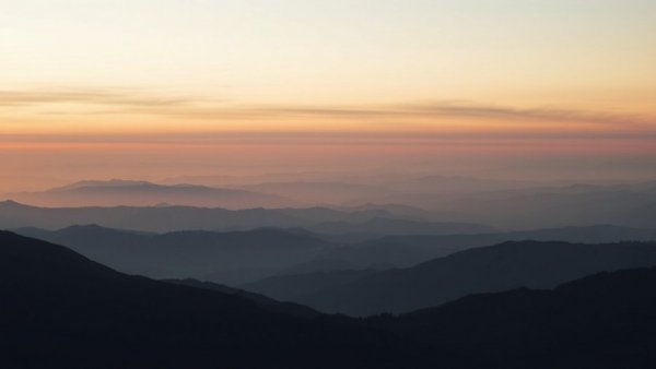 Calm mountain landscape at sunset with soft pastel sky.
