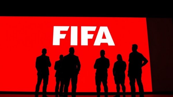 FIFA logo backdrop with silhouetted figures.