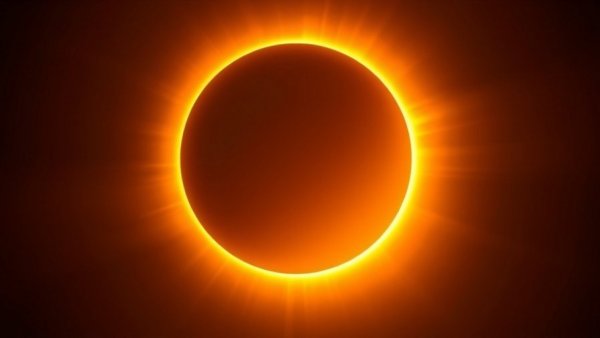 New Moon Solar Eclipse casting bright halo in dark sky.