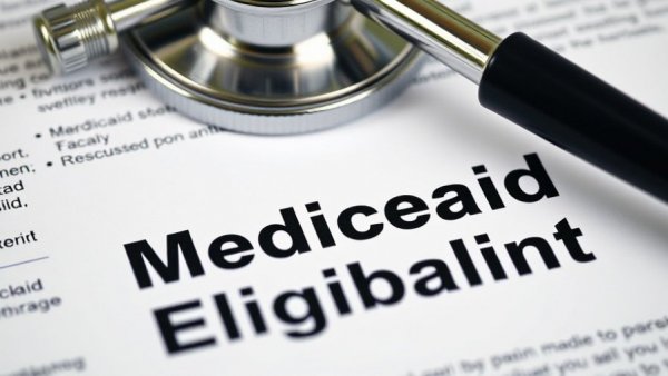Close-up of Medicaid eligibility document under stethoscope.