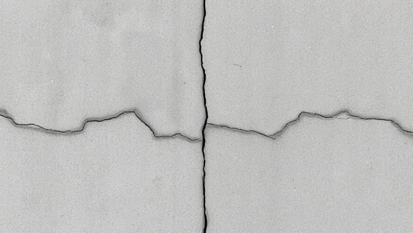 DIY concrete crack repair on visible cracked surface.