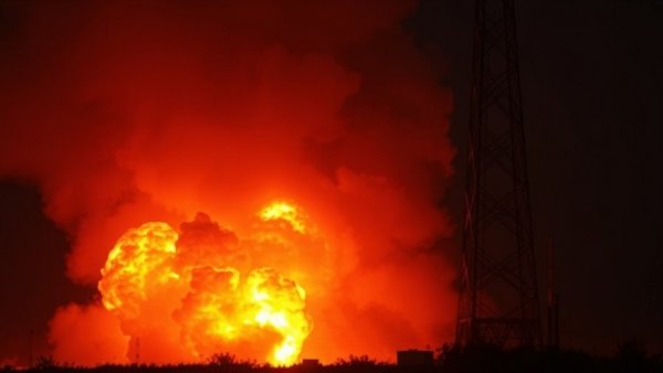 Venezuela State of Emergency: explosion scene near metal tower, smoky night.