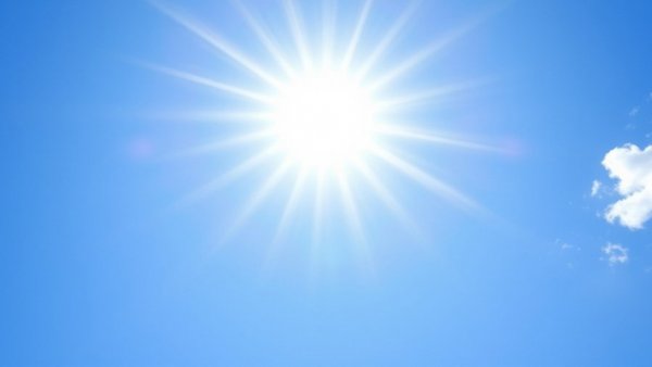 Clear blue sky with bright sun rays above Kansas City neighborhoods.