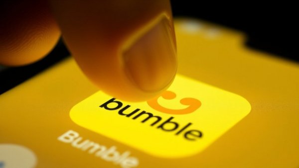Close-up view of Bumble app icon on glowing smartphone screen.