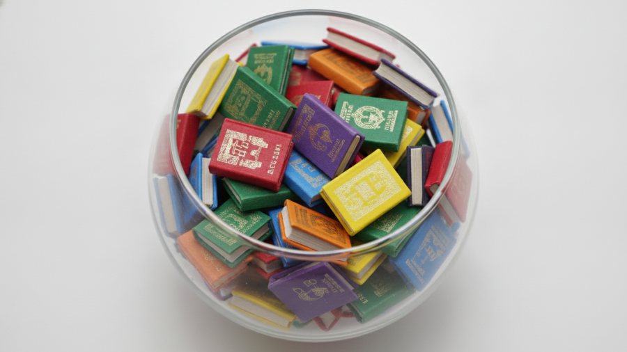 Colorful miniature books in a bowl highlighting community reading programs and family reading activities.