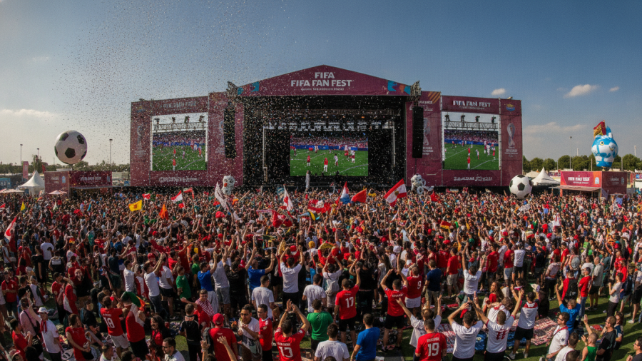 KC community spirit shines at FIFA Fan Fest with vibrant football fans under a bright blue sky.