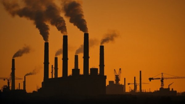 Industrial skyline with smokestacks and cranes on a hazy day