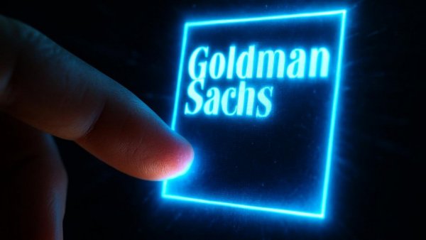 Goldman Sachs logo on screen with finger interaction, digital display.
