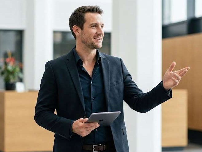 Businessman pointing right with a tablet, showcasing modern business insights.