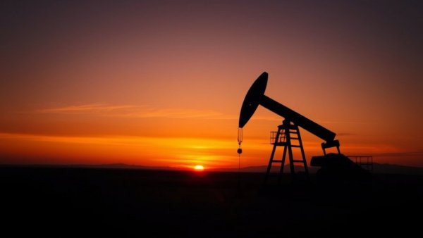 Oil pump silhouette at sunset illustrating high oil prices impact on economy.