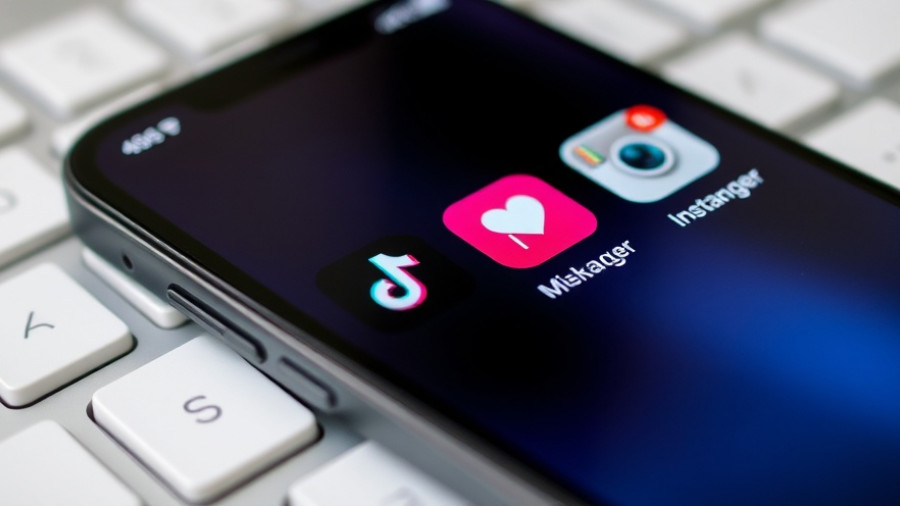 Smartphone screen with social media apps related to Texas app age verification law.