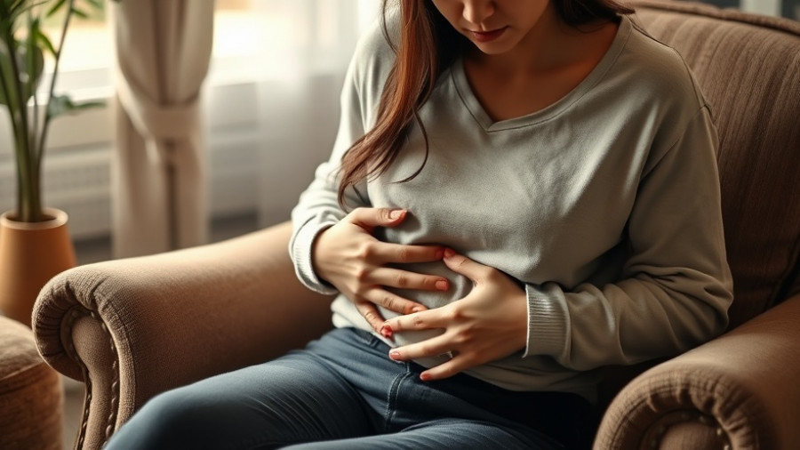 Woman holding stomach in discomfort, sitting on a chair indoors.