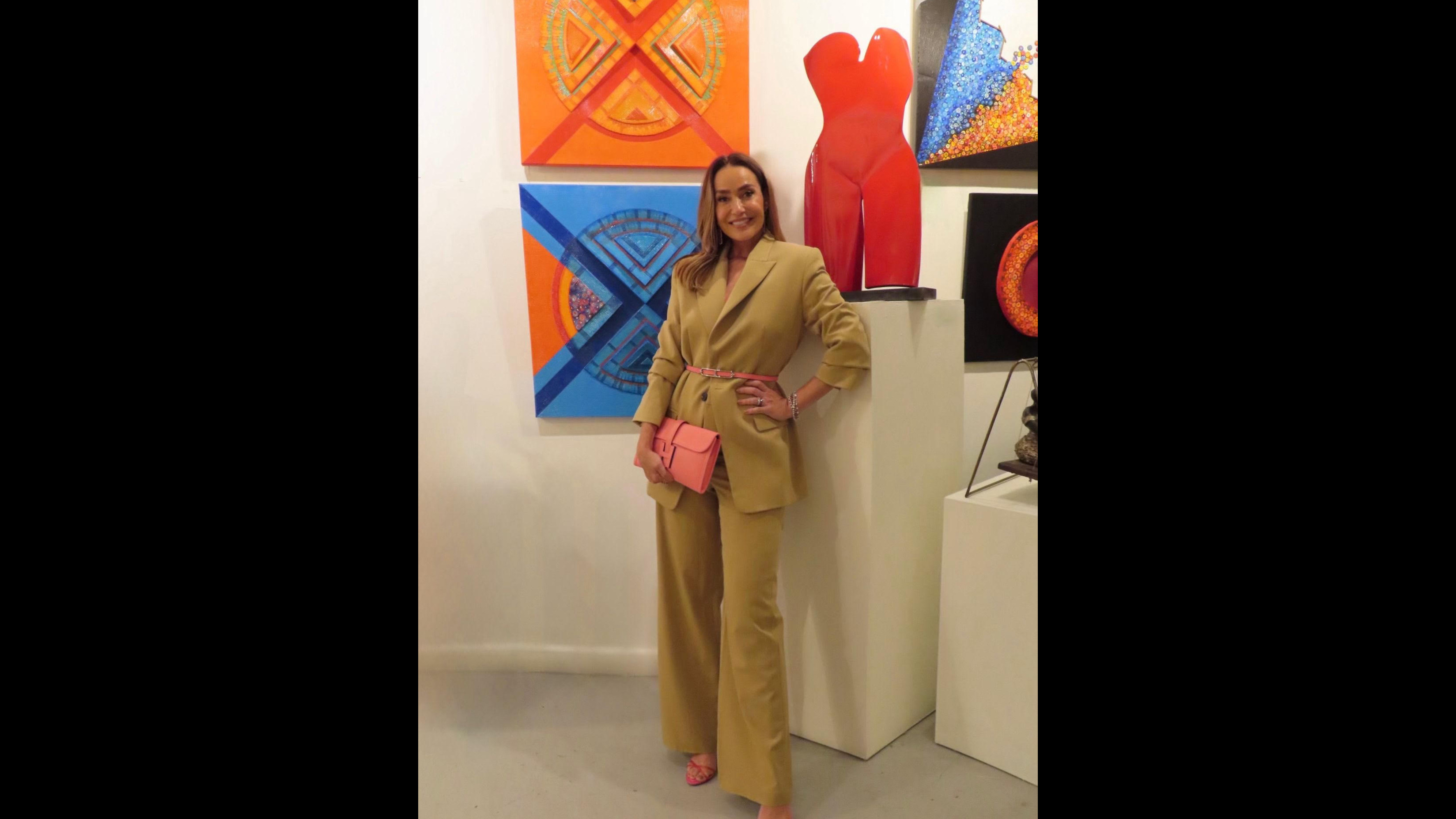 Woman smiling while filmed at Mylene Costa's Sculptures exhibit.