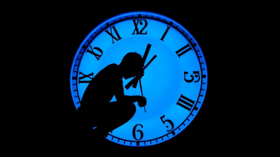 Silhouette with a glowing clock face, symbolizing permanent daylight saving time.