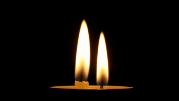 Dual candle flames against black background with warm glow