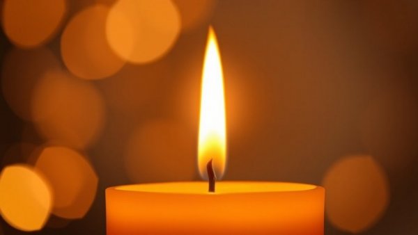 Candle glowing softly in dim light for Alex Duong soft tissue cancer.