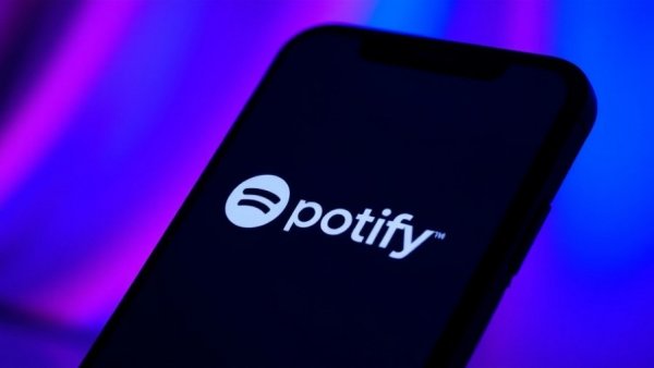 Spotify logo on a smartphone screen in a colorful background.