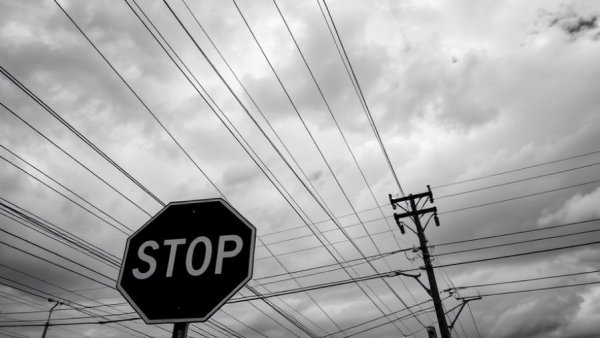 Stop sign under power lines against cloudy sky, finance on vehicle concept.
