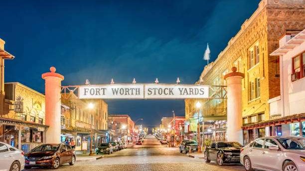 Historic Fort Worth Stock Yards with horse-drawn carriage, vibrant scene.