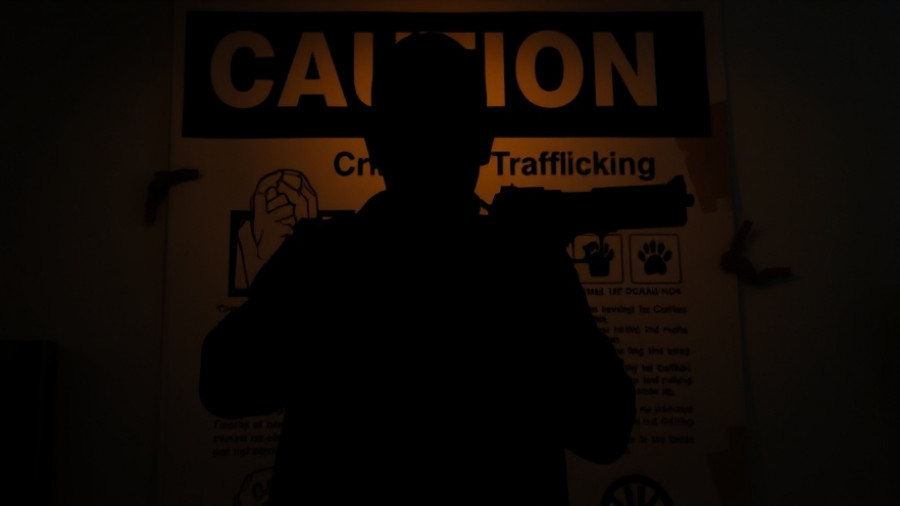 Silhouetted figure with firearm, highlighting American-made guns in Mexican crime.