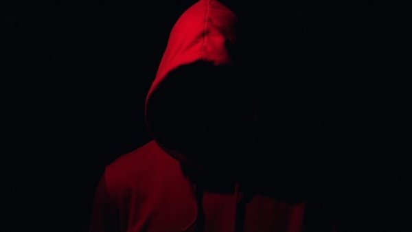 Hooded figure in dramatic lighting representing Crime in America.