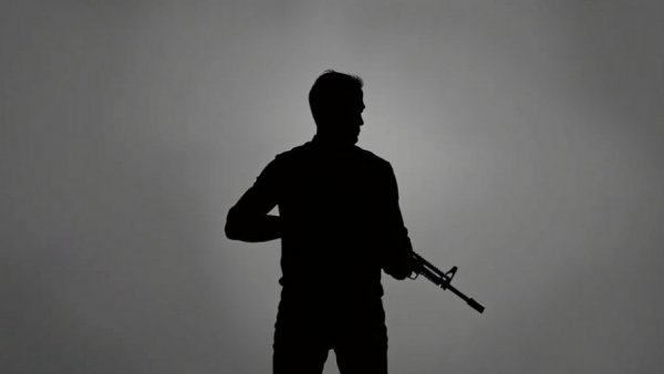 Silhouette of person with rifle, gun control theme
