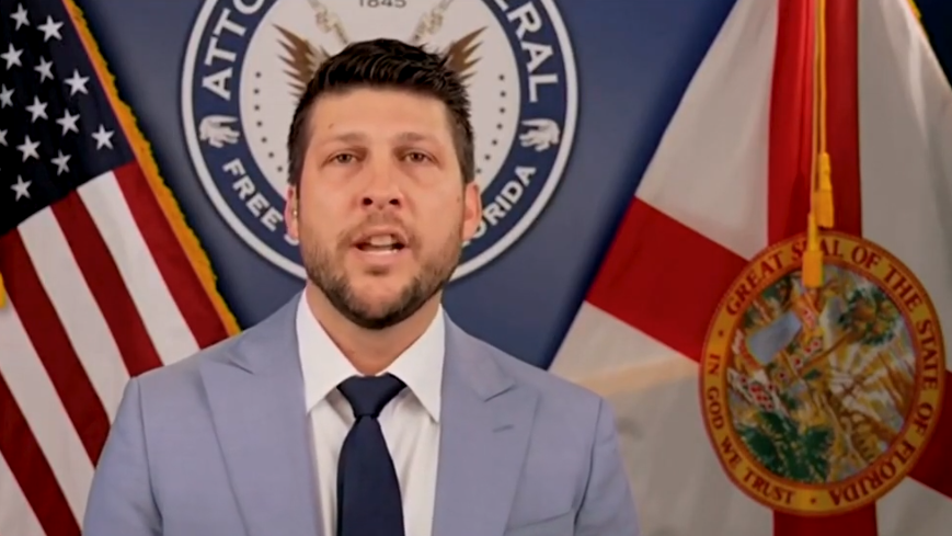 Stern Florida AG Uthmeier holding legal document, representing youth gun rights.