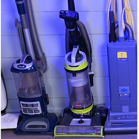 Dyson cordless vacuums displayed with purple lighting.