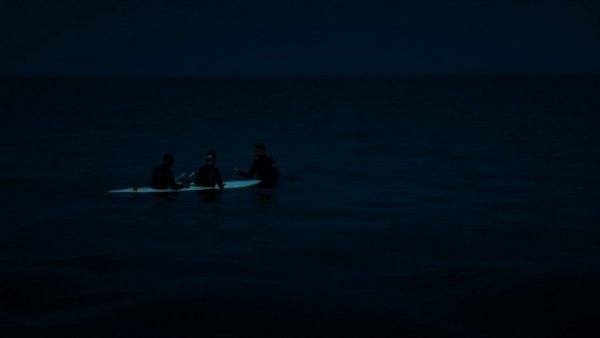 Educators discuss marine life at night in a serene ocean setting.