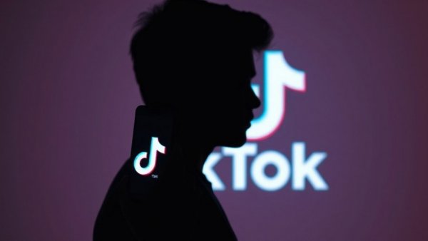Dramatic silhouette holding phone with TikTok, best marketing tools for SMBs.