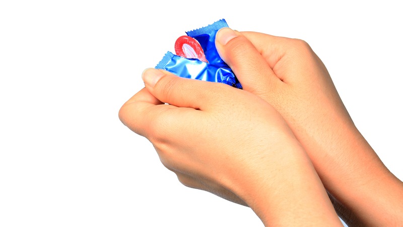 hands opening a condom 