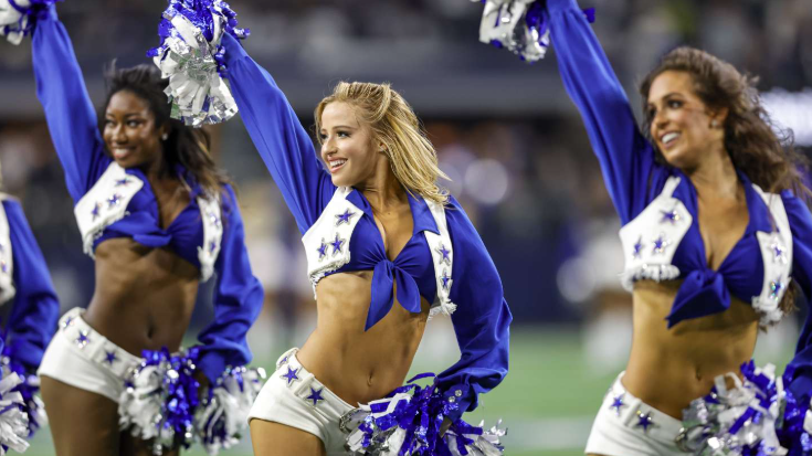 Dallas Cowboys cheerleaders in blue and white uniforms cheering at an event.