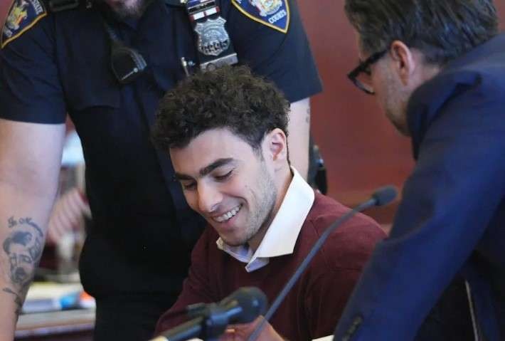 Luigi Mangione smirking in court during pretrial hearings on police conduct.