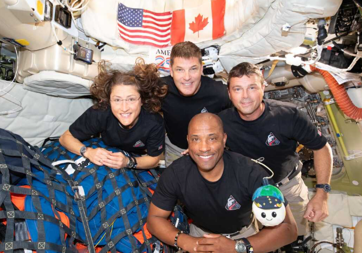Astronauts in zero gravity inside spacecraft during Artemis II mission.