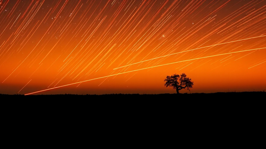 Dramatic meteor shower over a silhouetted horizon, highlighting Halloween fireballs risks.