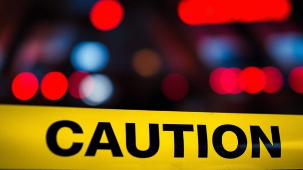 San Antonio local news: Caution tape with blurred emergency lights.