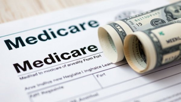 Medicare enrollment form with dollar bills, highlighting financial considerations.