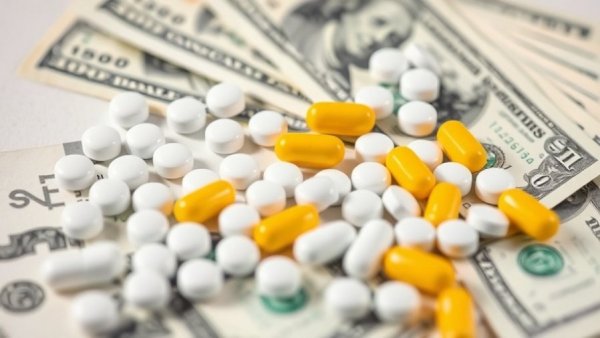 Pills on hundred dollar bills highlighting Pharmacy Benefit Managers leadership.