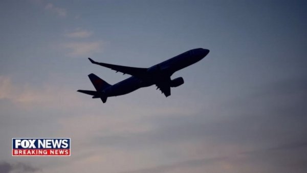 Breaking news today: Silhouette of airplane flying against evening sky.