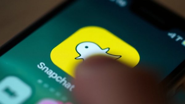 Close-up of Snapchat app icon being tapped.