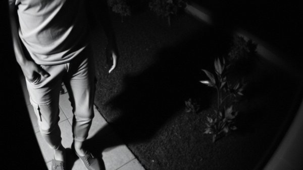 Breaking news footage of a person in monochrome surveillance shot.