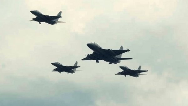 Military aircraft flying over Iran's gray sky