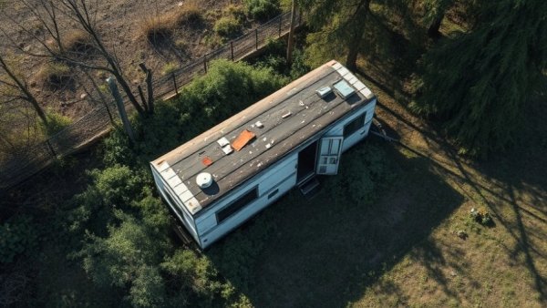 Aerial view of a neglected yard with a decrepit trailer related to Texas Killing Fields cases.