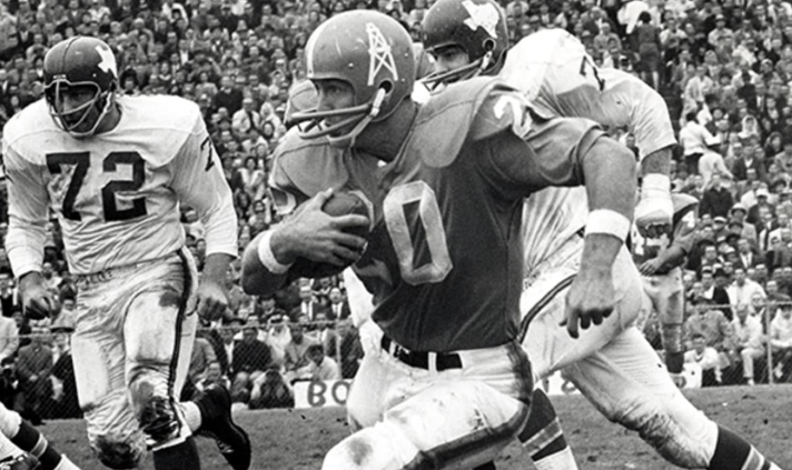 Black and white photo of a young football player in a stadium.
