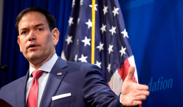 Professional man speaking in front of flags, activist visa holders discussion.