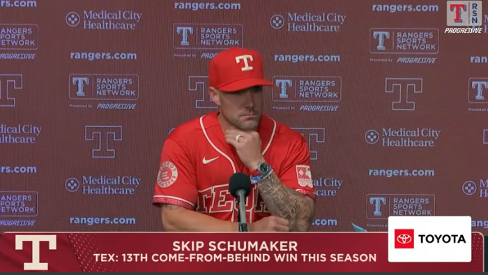Athlete at press conference discussing overcoming adversity in sports.